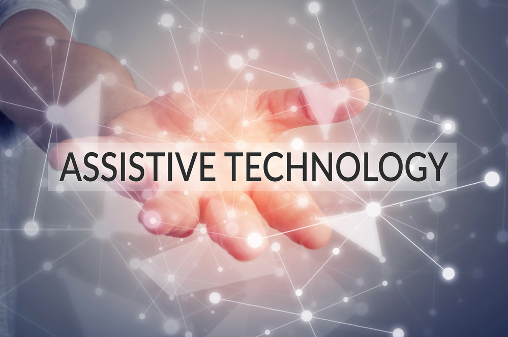 A hand holding a sign with the words, Assistive Technology.