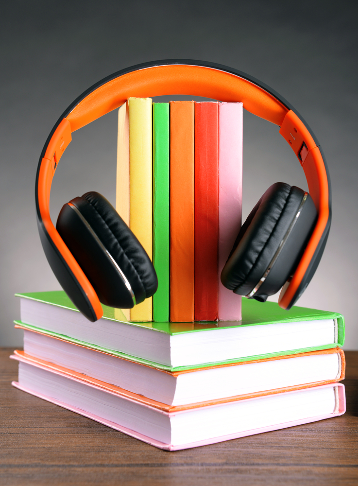 Photo of Books and headphones as audio books concept on grey background