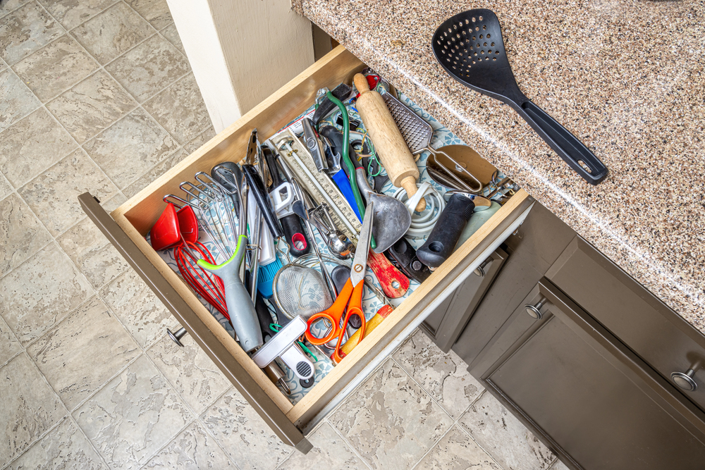 A kitchen drawer that is untidy.