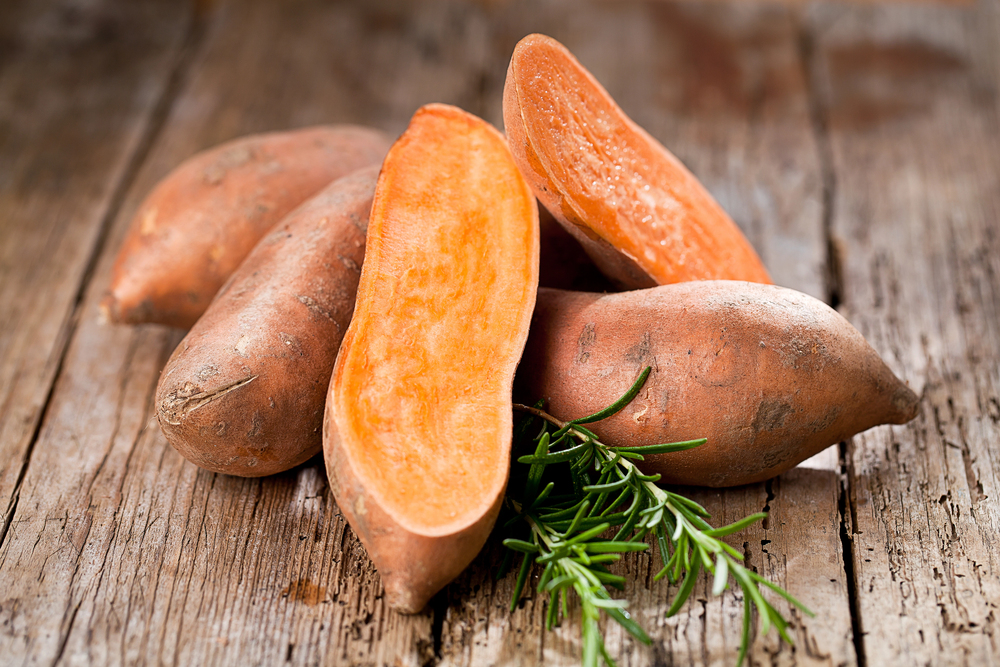 Sweet potatoes cut up on a board.