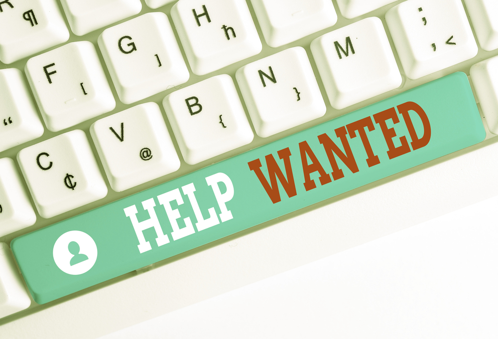 A computer keyboard has the words, Help Wanted, on the space bar.