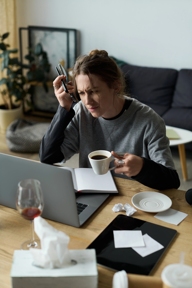 A woman is sitting at a desk feeling frustrated