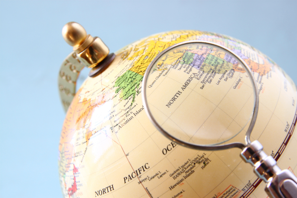 A photo of an old World Globe with a magnifying glass.