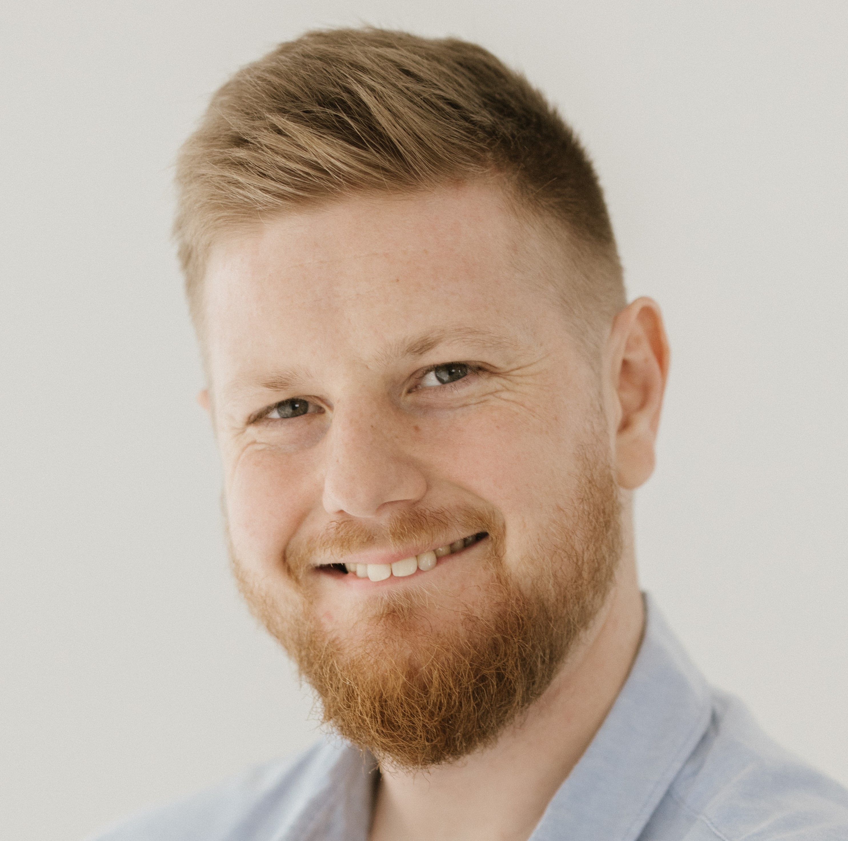Alex Bey has light brown hair and is smiling at the camera.