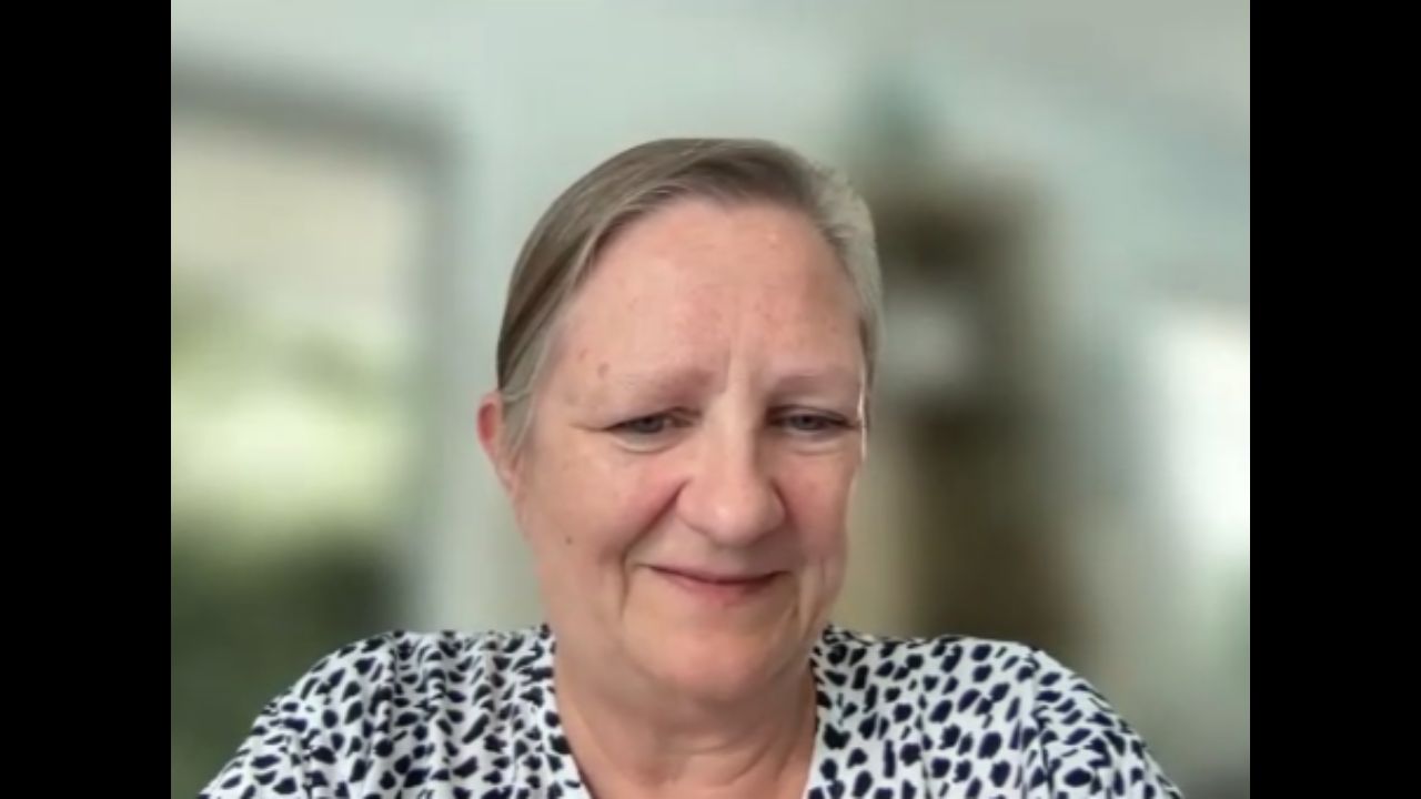 Lisa Young is wearing a patterned black and white shirt.