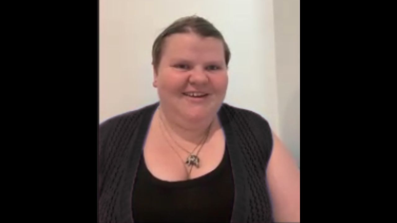 Luna is wearing a black t-shirt and smiling at the camera.